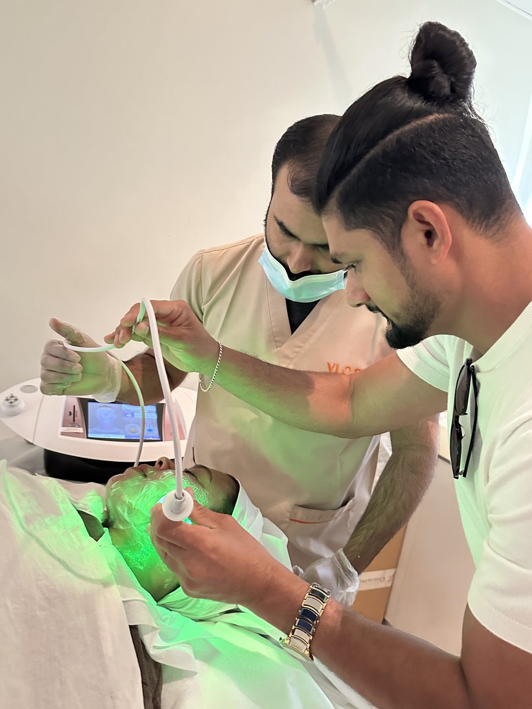 Practitioners performing an LLLT laser facial treatment